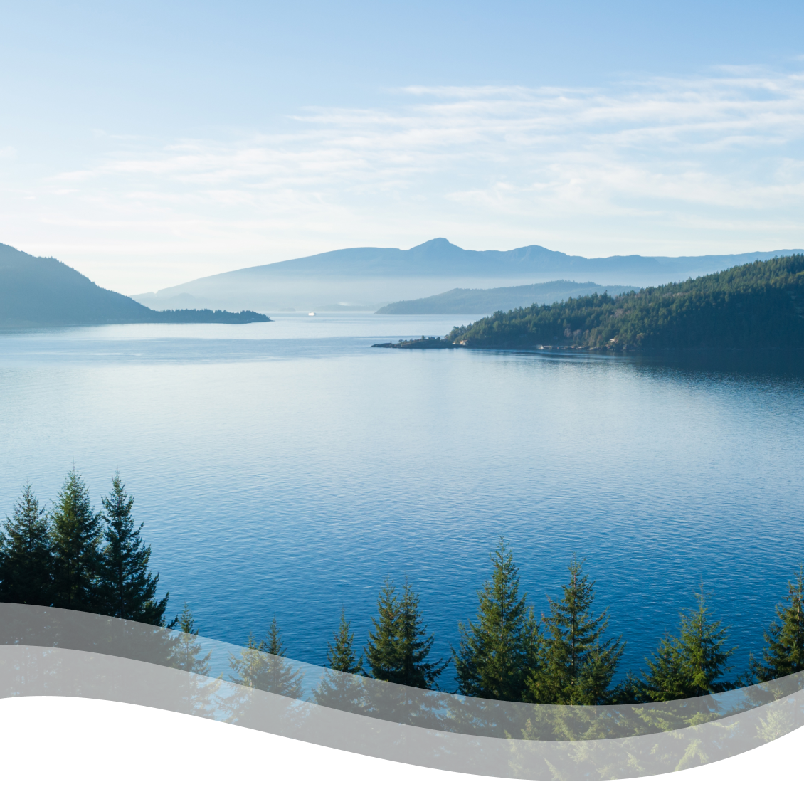 A scenic view of calm water and mountains in the background.