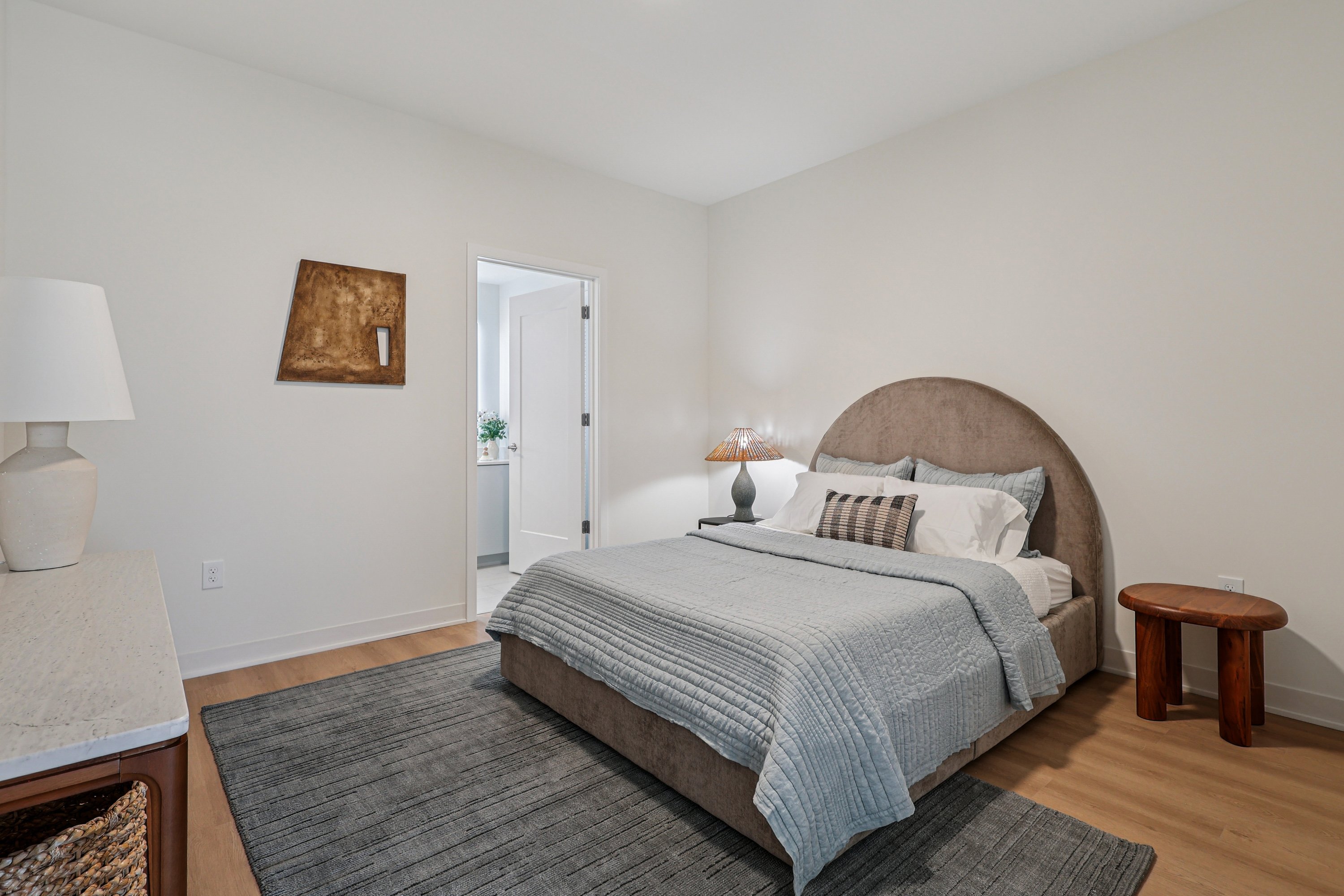 A bedroom with a large bed and two lamps