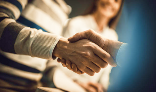 Close-up shot of people shaking hands.