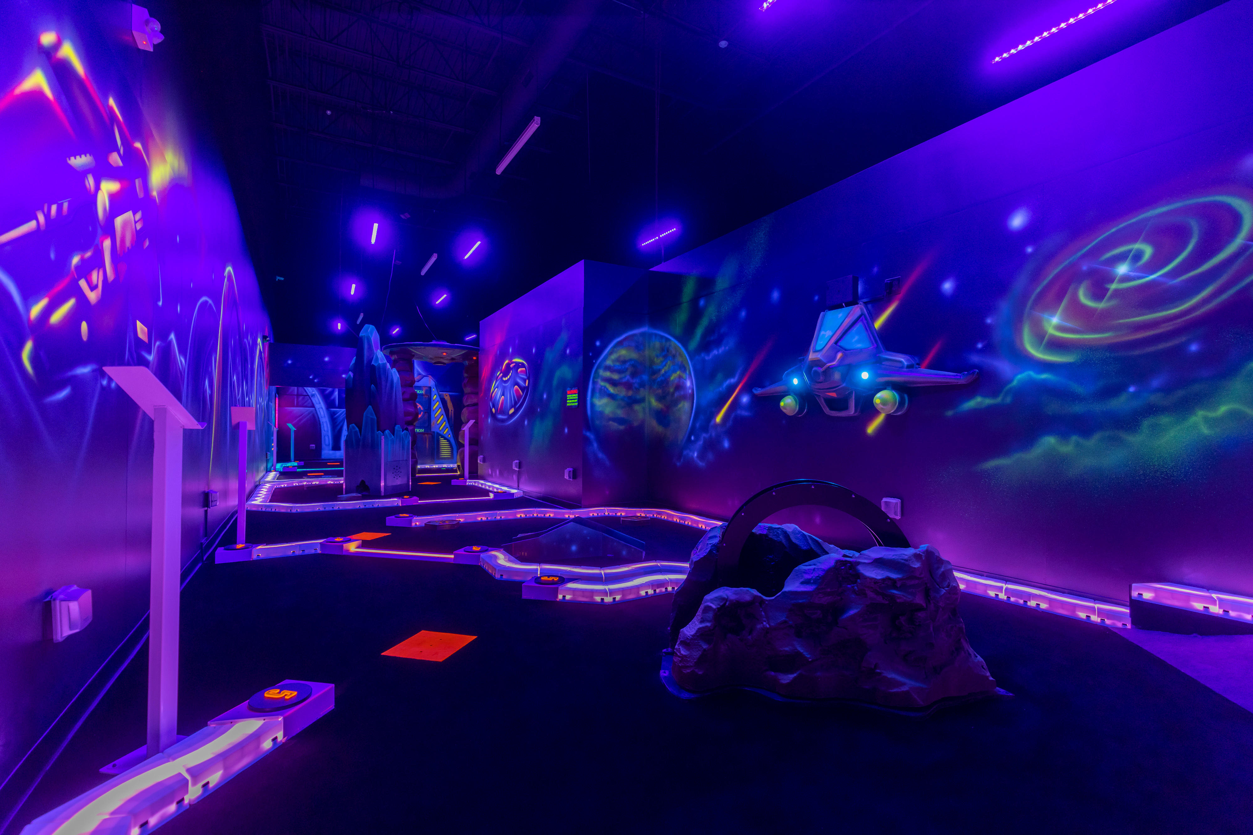 a nine-hole glow-in-the-dark space-themed mini golf experience,