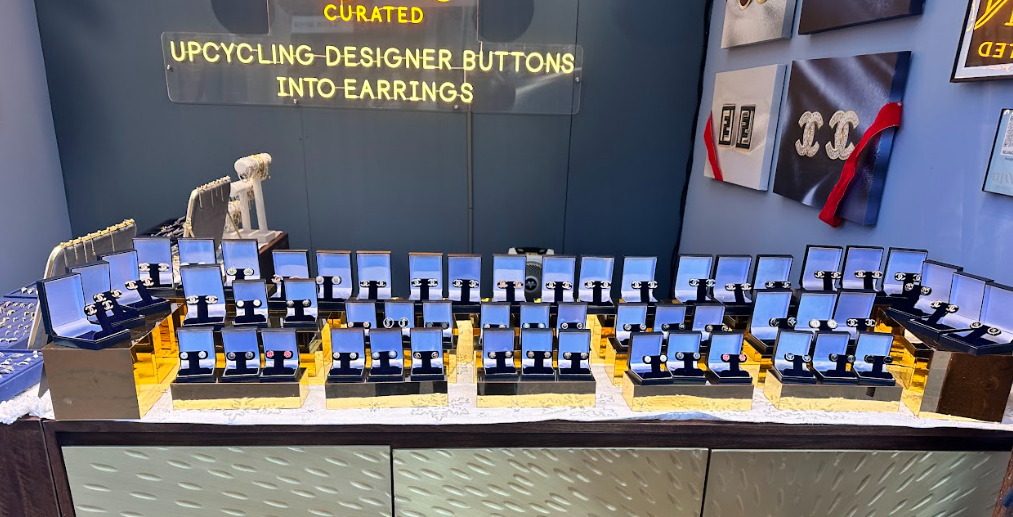 Eliana Curated displays a wide selection of handcrafted earrings made from upcycled designer buttons, beautifully presented in elegant jewelry boxes for sustainable and stylish accessorizing.