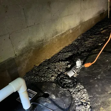Encapsulated crawl space covered with a black vapor barrier across the floor. Support posts, ductwork, and moisture protection materials create a sealed environment beneath the home.