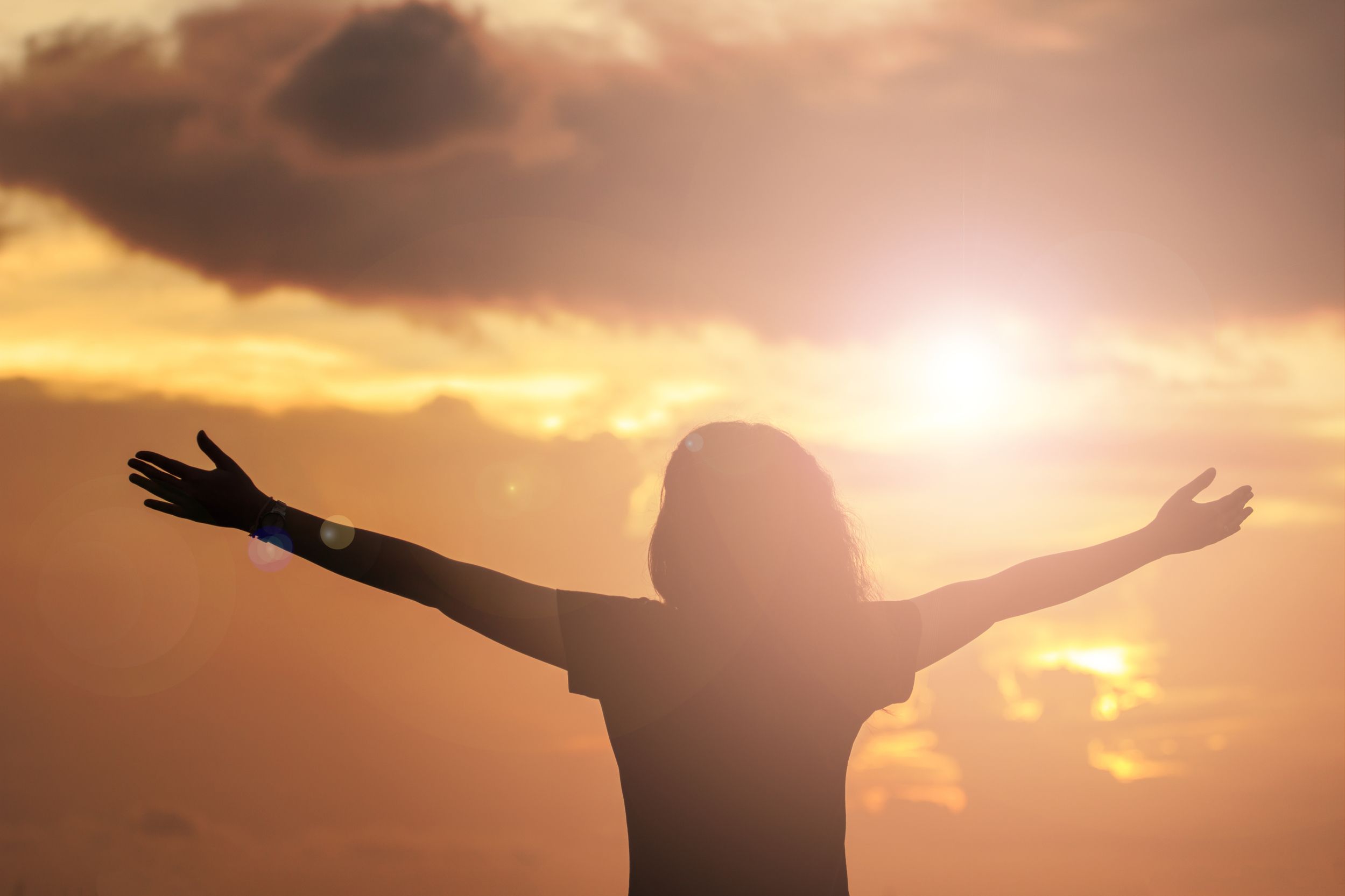 Worshipper raising her arms in praise