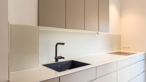 Küchenrückwand aus satiniertem Glas für eine ruhige Optik und pflegeleichten Spritzschutz.
