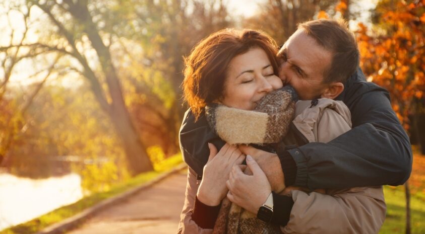 Middle aged couple embracing in autumn.