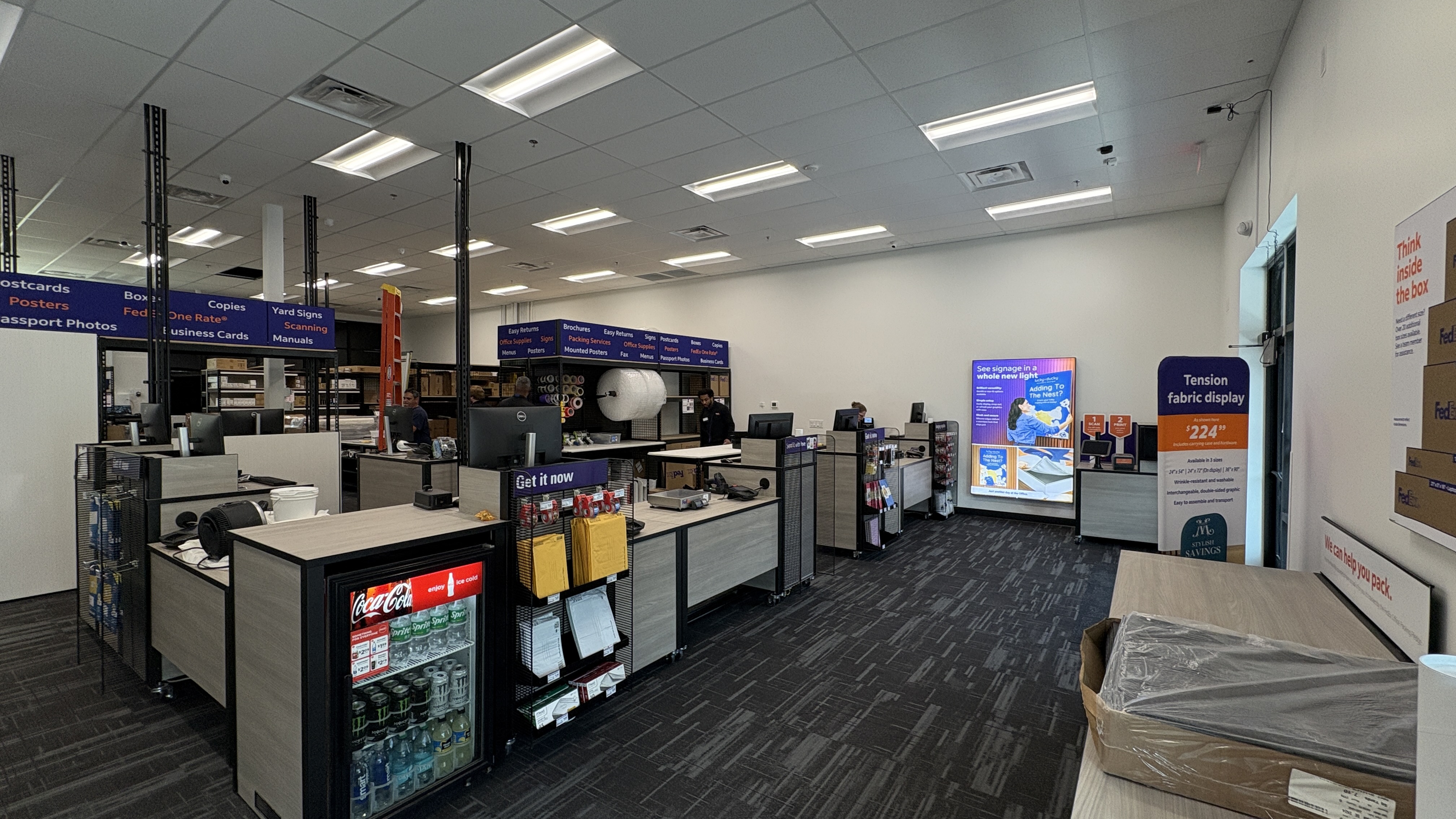 A wide view of the FedEx Office interior in Atlanta, showing the full-service counters, retail displays, and packing service area.