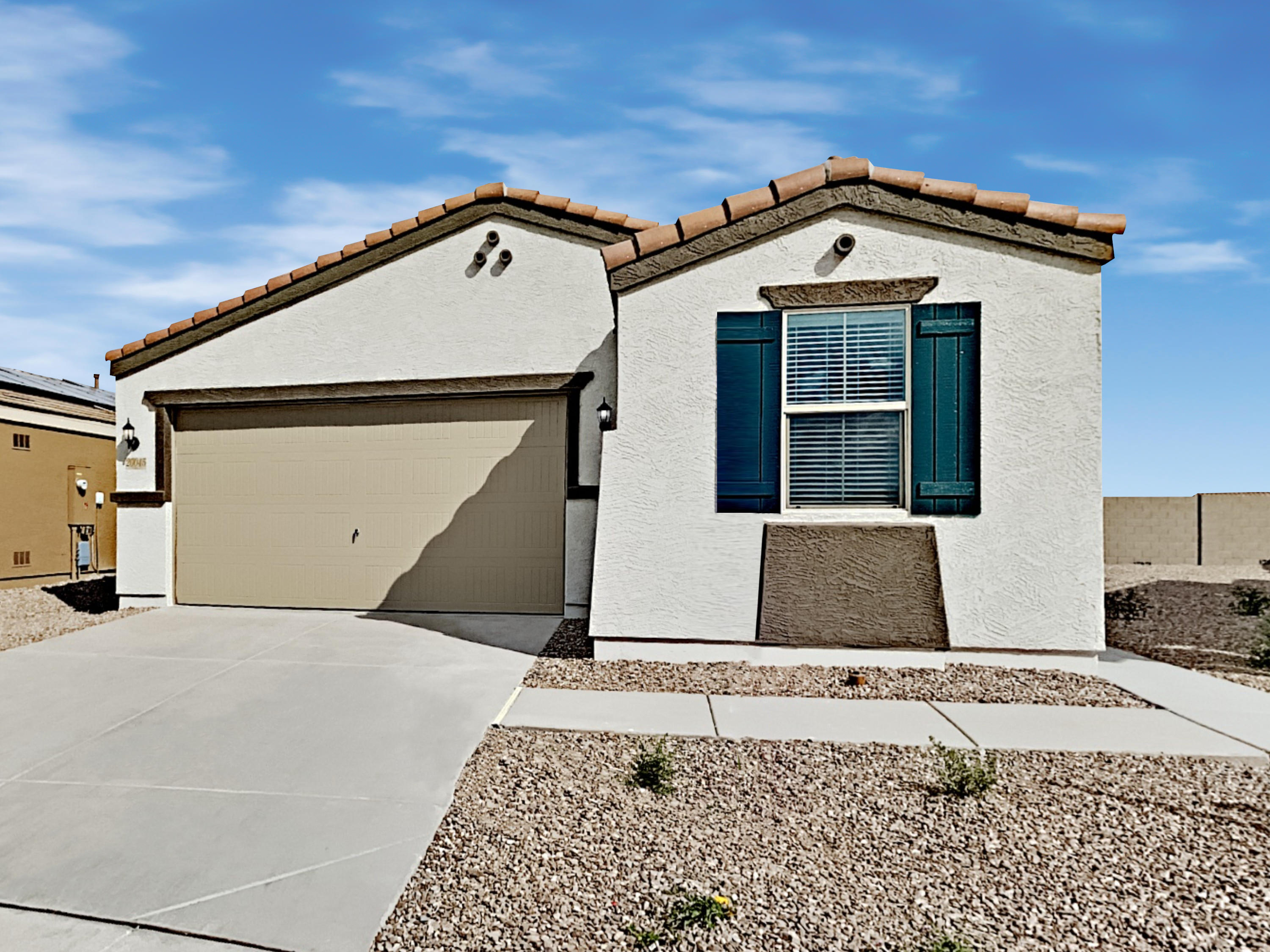 Front of home shot with attached two-car garage and wrap around walkway at Invitation Homes Phoenix.