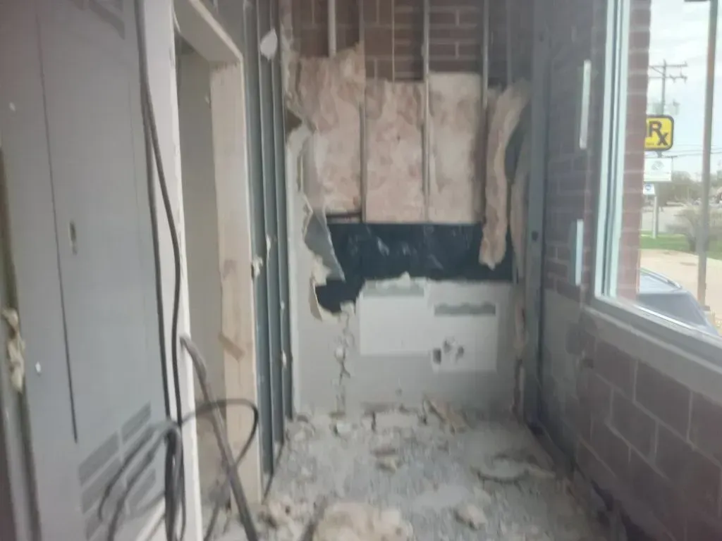 Interior space under demolition with partially removed drywall, exposed insulation, and debris on fl 