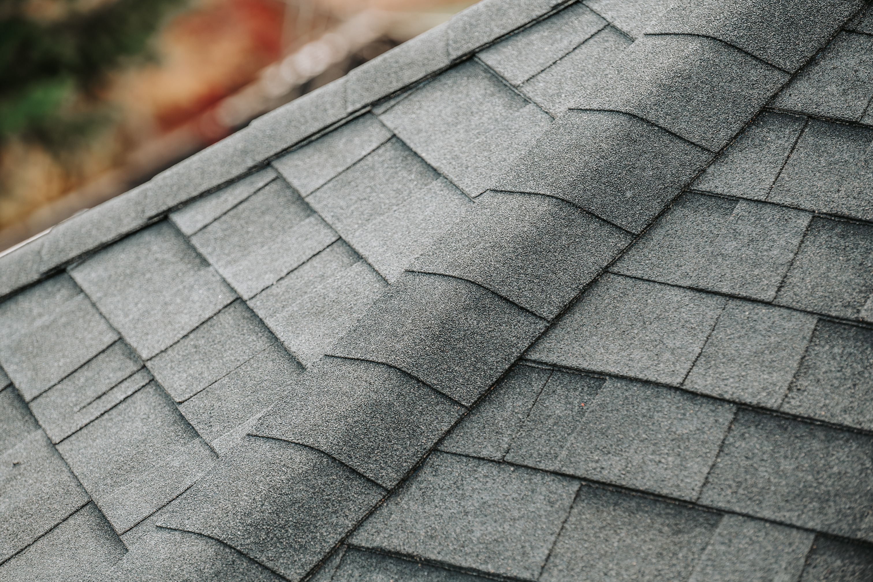 Close-up view of overlapping asphalt shingles and roofing details on a residential roof. 