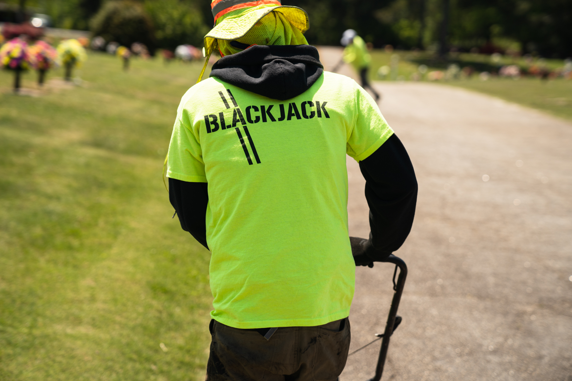 Contactor wearing a neon green t-shirt displaying Blackjack Paving's logo