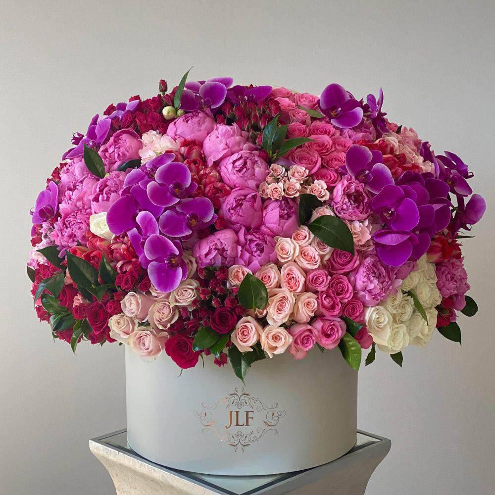 A Grandiose Romance
SKU: JLF002555
This lovely-romantic grandiose box is filled with the most magnificent blooms in the most magnificent hues.Classic roses, orchids, peonies, tulips and hydrangeas are used in this beautiful creation in our largest box thus far.