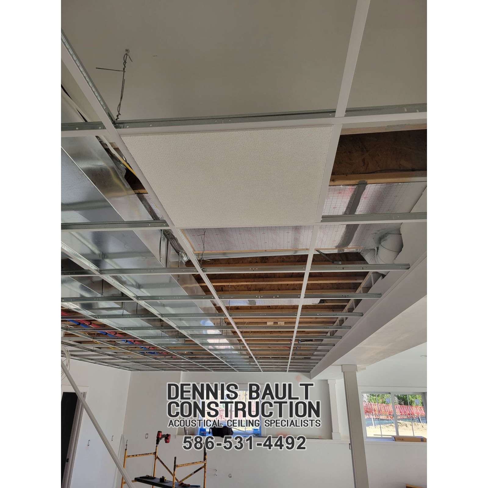 Looking up at the residential walk-out basement, the drop ceiling grid is precisely installed. The clean lines form a sturdy frame, ready for the acoustical ceiling tiles. The metal grid reflects soft light, adding a polished look while promising a functional, stylish finish once the tiles are in place.