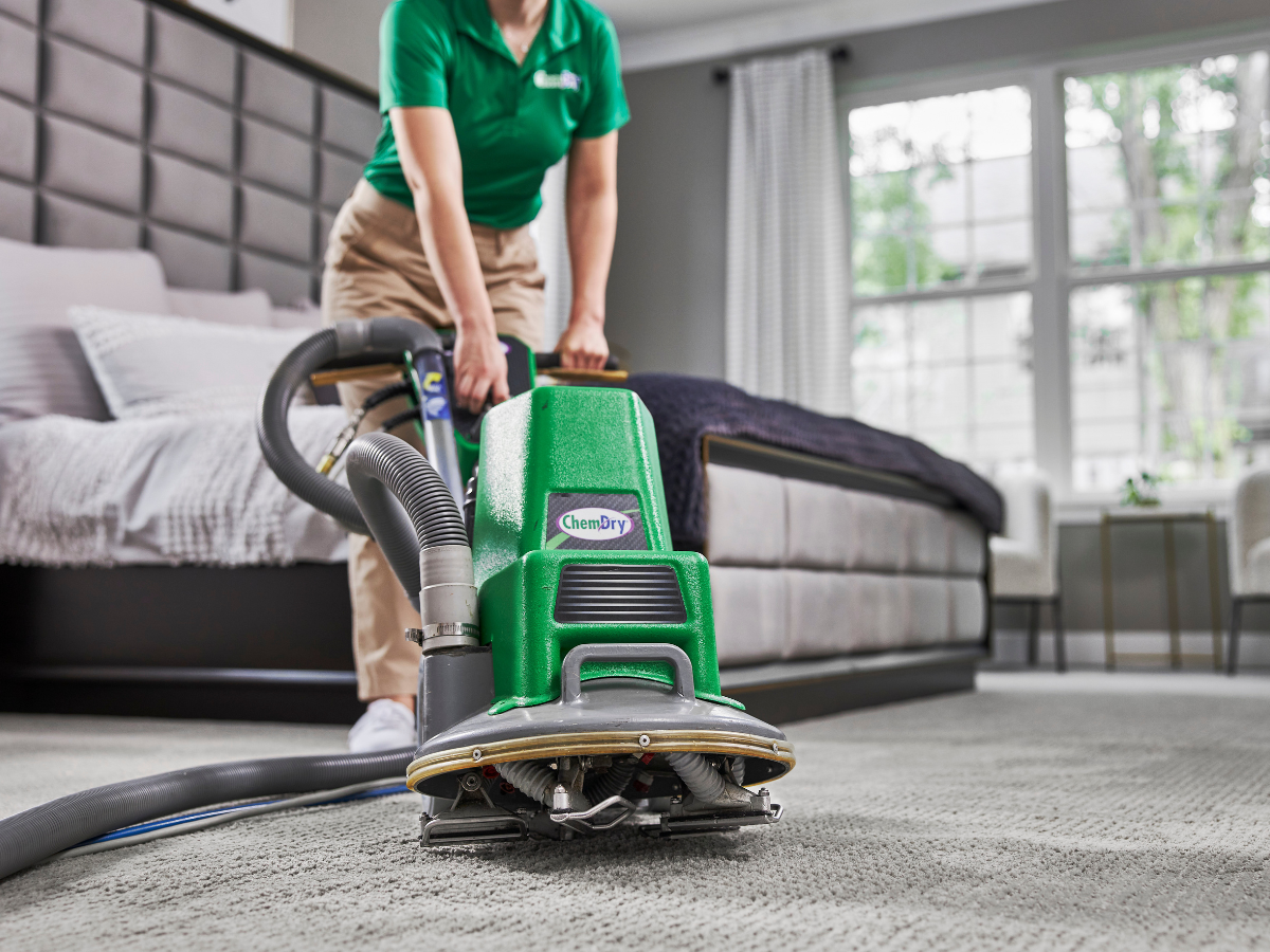 Chem-Dry tech using a carpet cleaning powerhead in a bedroom