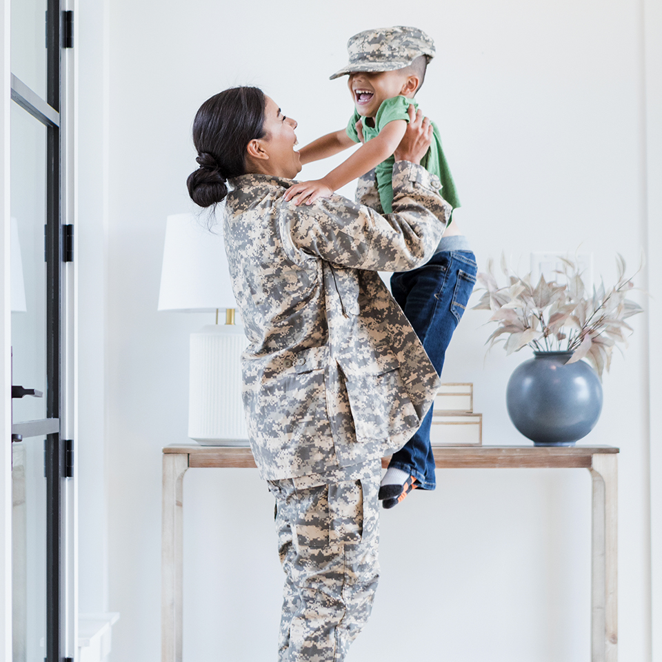 A woman in camo holding a young child