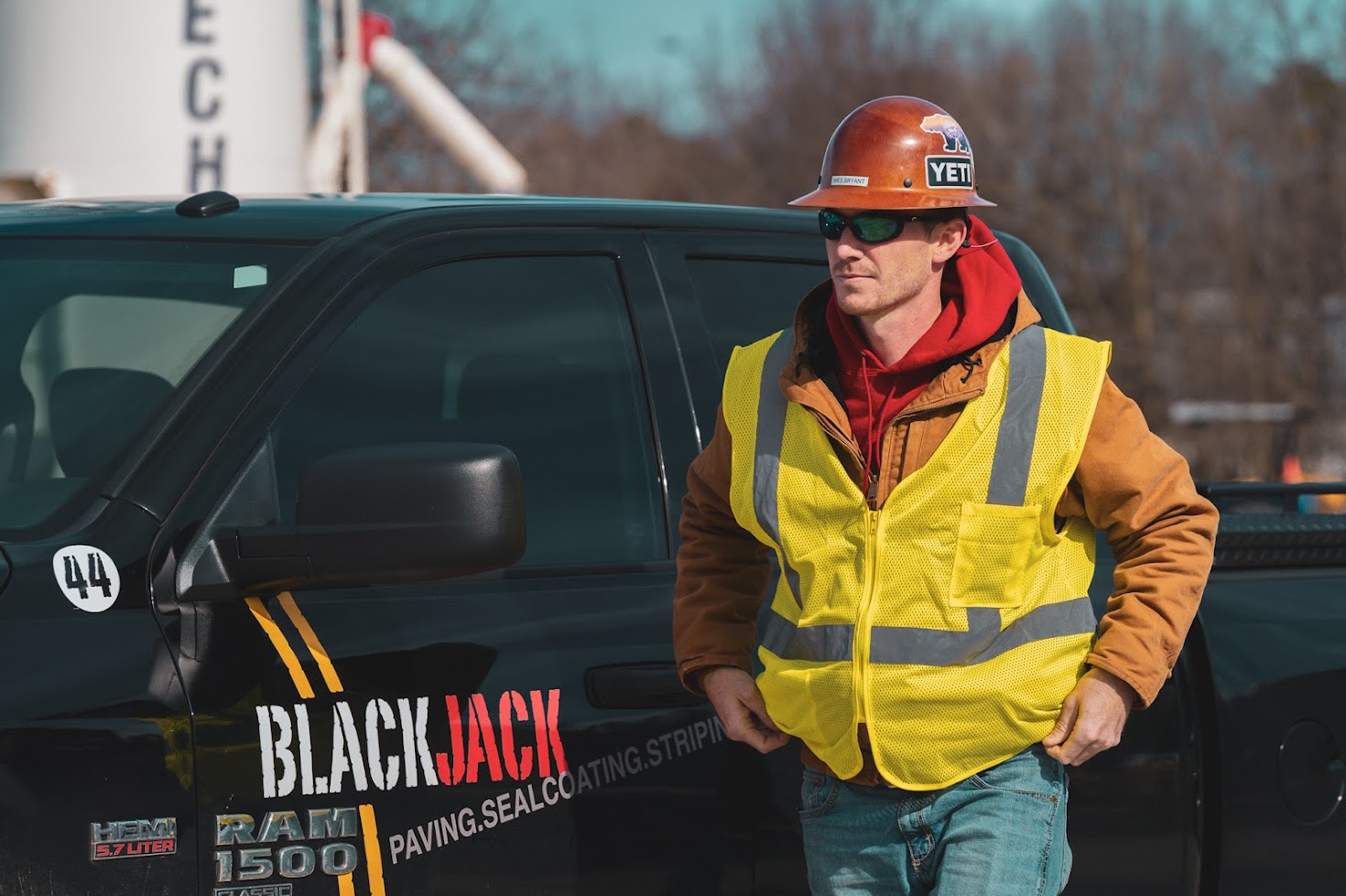 Man standing next to a blackjack paving truck