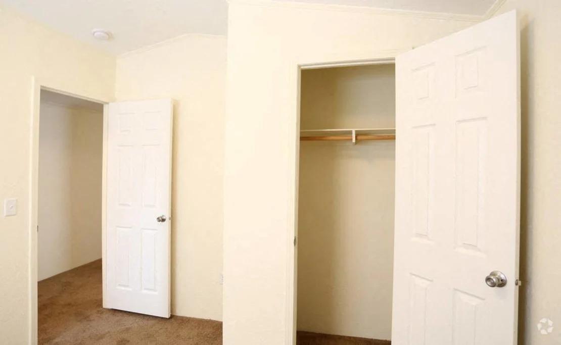 an empty room with a closet and a door open