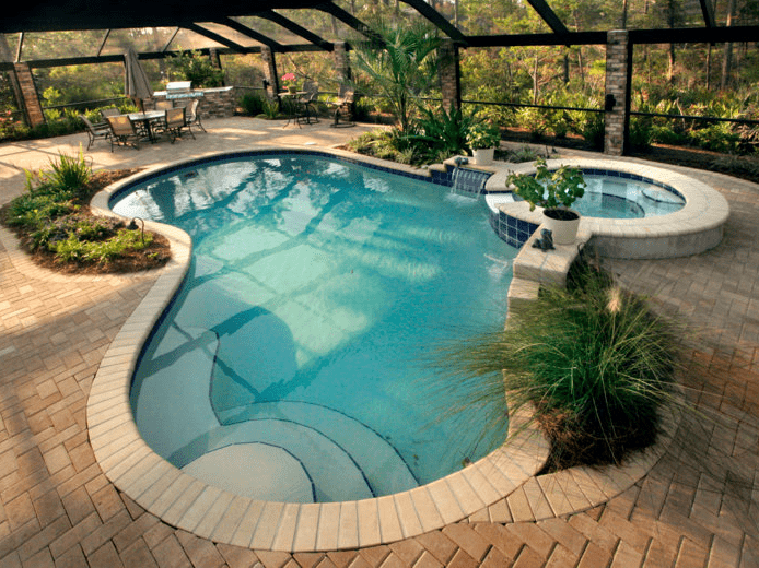 Kidney shaped pool with spa and beautiful landscape