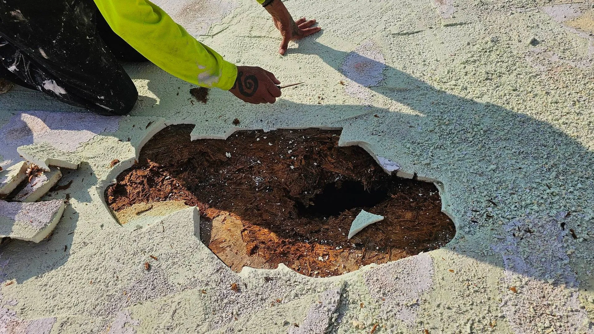Technician removing damaged spray foam roofing to expose deteriorated substrate before completing pr 