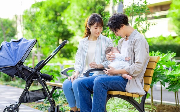 ベビーカーと赤ちゃんを抱っこする夫婦