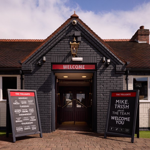 The welcoming entrance to The Tollgate, showcasing the pub's distinctive Grandstand branding.