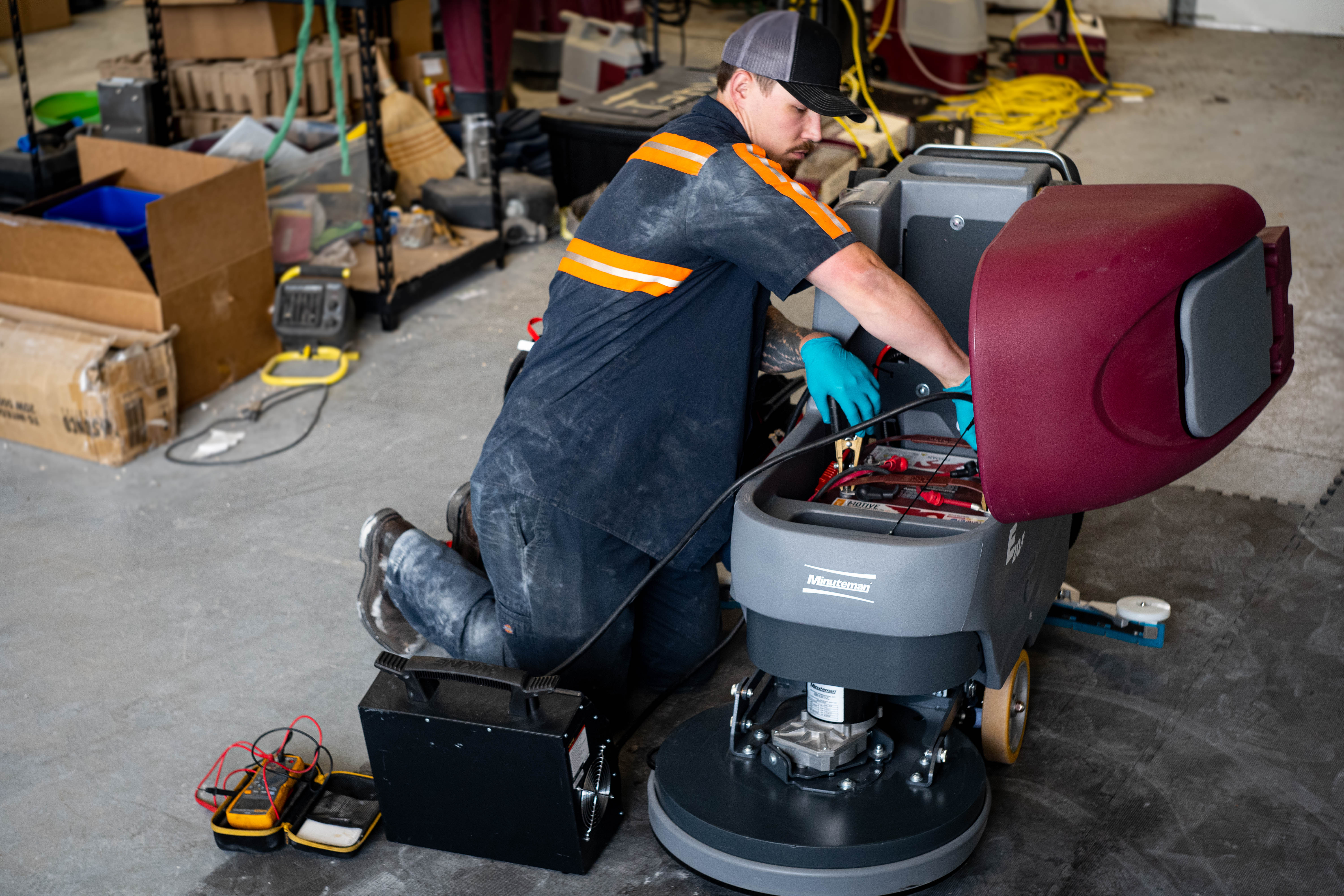 A WaySolutions field technician hooks up a heavy-duty Viking load tester to the battery bank of a Minuteman E20 walk-behind floor scrubber. By performing rigorous power system diagnostics in Layton, Utah, our technicians guarantee your commercial cleaning fleet has the endurance and electrical surge needed to survive the toughest shifts.