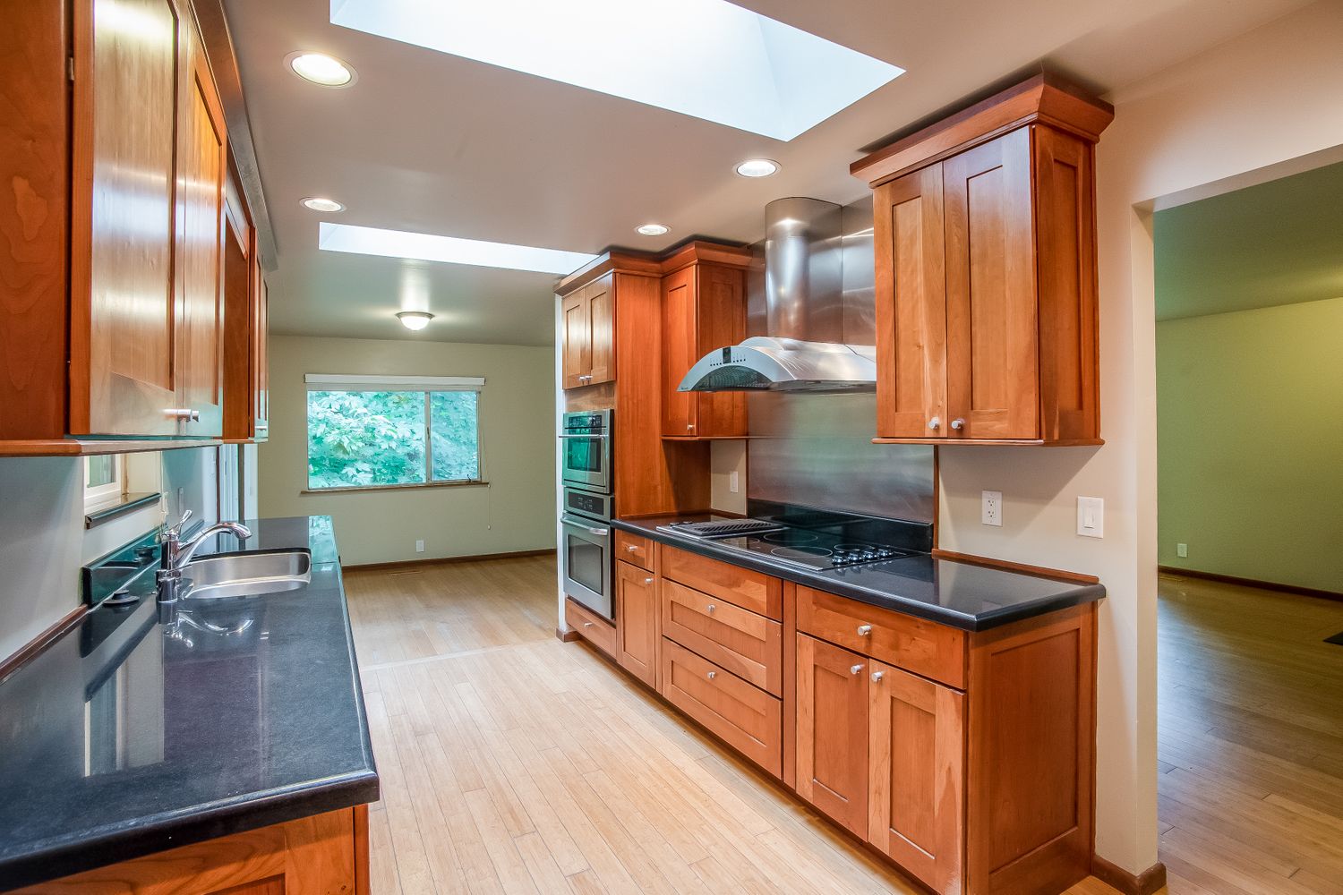 Bright kitchen with rich wooden cabinets at Invitation Homes Seattle.