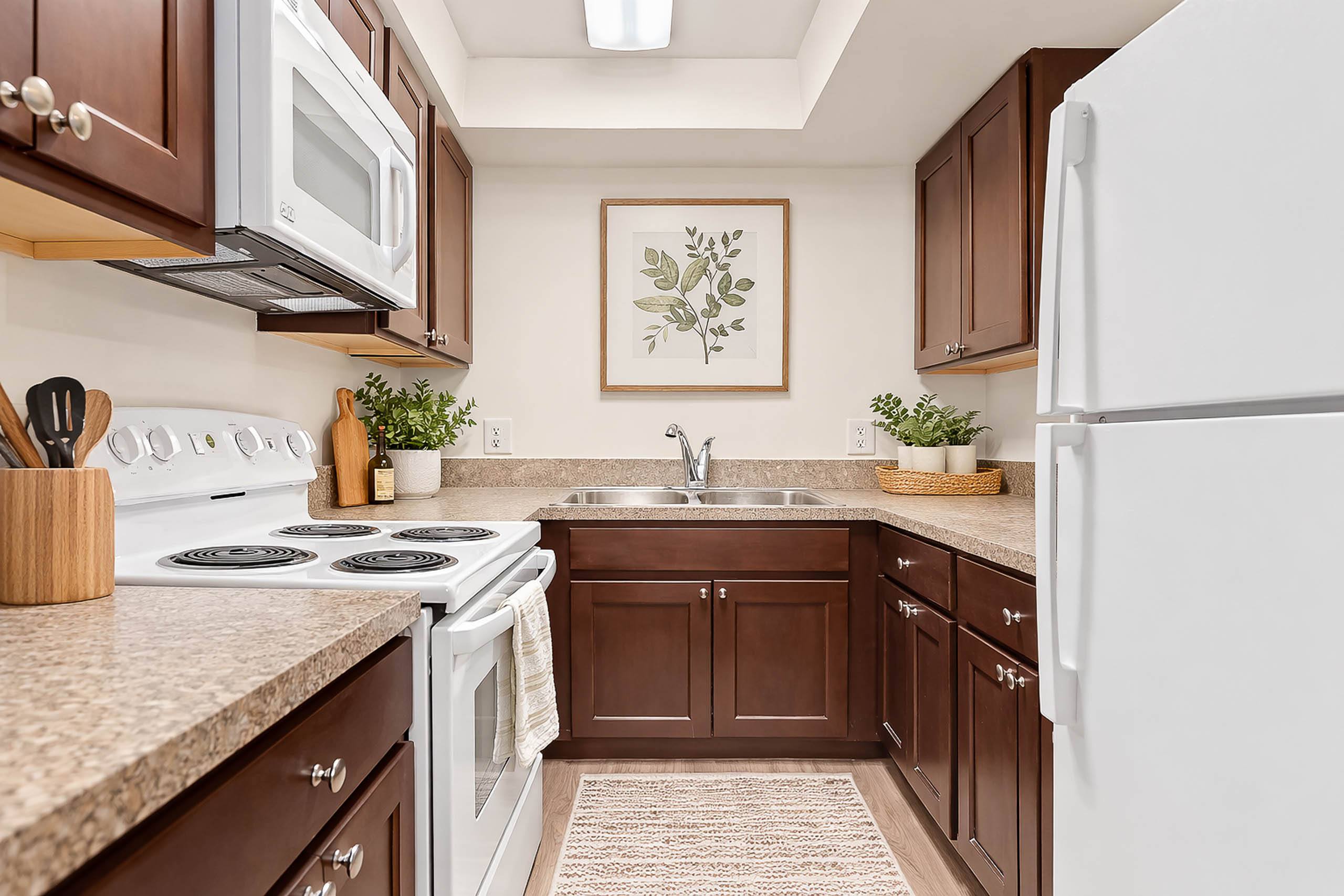 A kitchen with brown cabinets and a white stove top oven