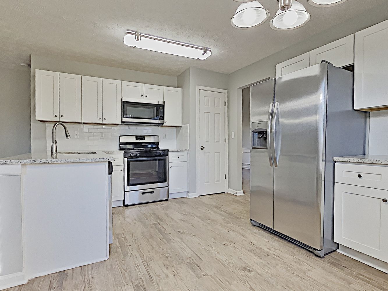 Bright, modern kitchen with stainless steel appliances at Invitation Homes Atlanta.