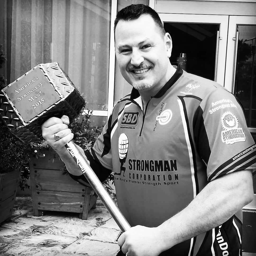 Dr. McDougle holds the America strongest man trophy presented to Dimitar Savatinov originally from Bulgaria