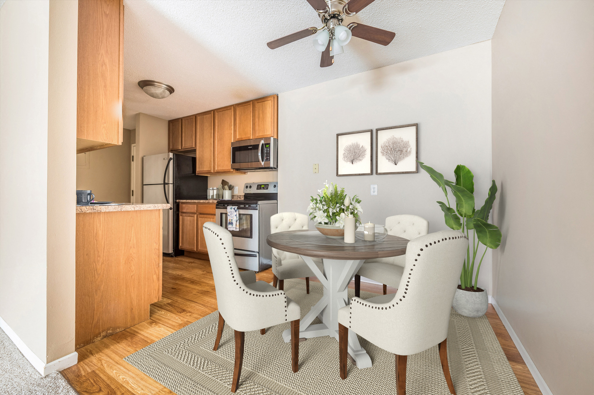 a dining area with a table and chairs and a kitchen in the background at Heritage Hills Apartments, Bloomington