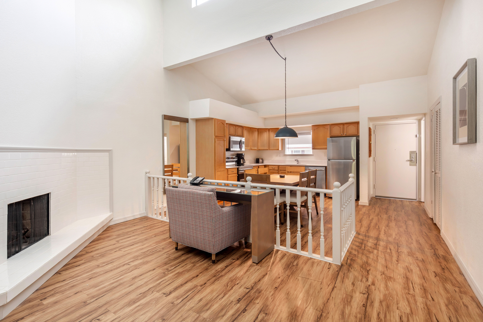 The living area in an accommodation at Bryan's Spanish cove. It features a fireplace and seating with nearby kitchen.