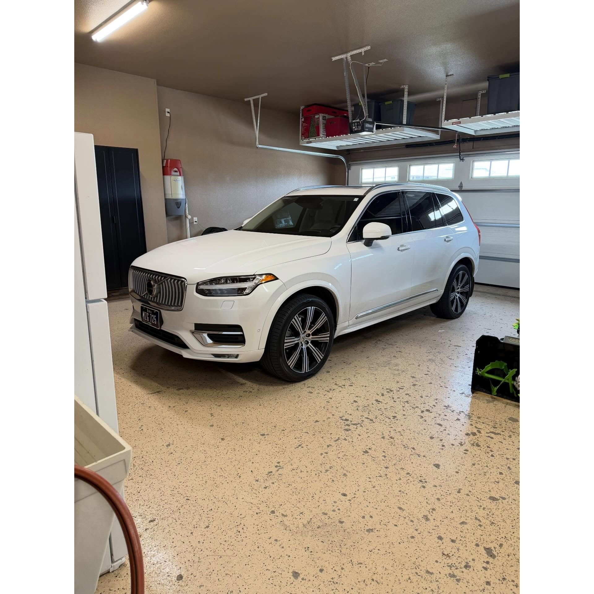White luxury SUV in a residential garage after professional detailing, showcasing a clean exterior finish, polished wheels, and high-end vehicle care by AMT Mobile Detailing.