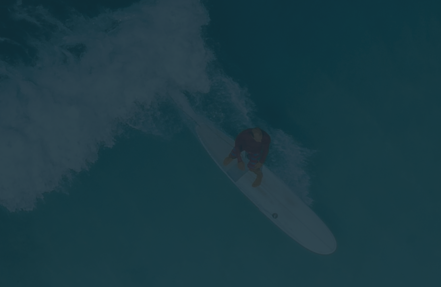 Aerial view of a surfer catching a wave.