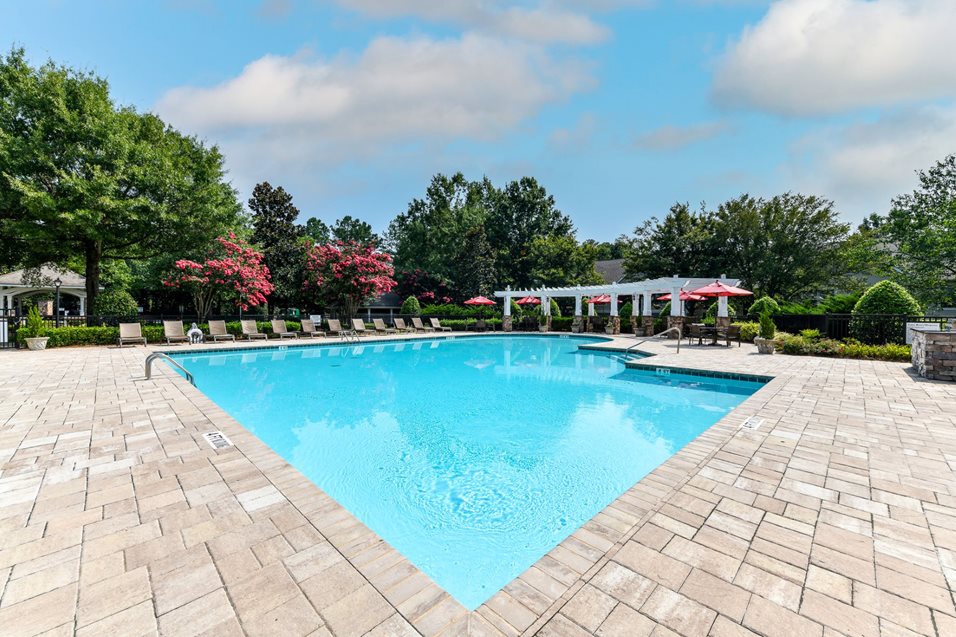 Refreshing Swimming Pool with Relaxing Poolside Lounge Chairs at Lake Cameron Apartment Homes