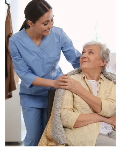 Caregiver supporting senior patient during in-home care visit.