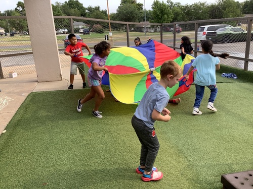 Teamwork, laughter, and colorful fun — parachute play encourages coordination and cooperation!