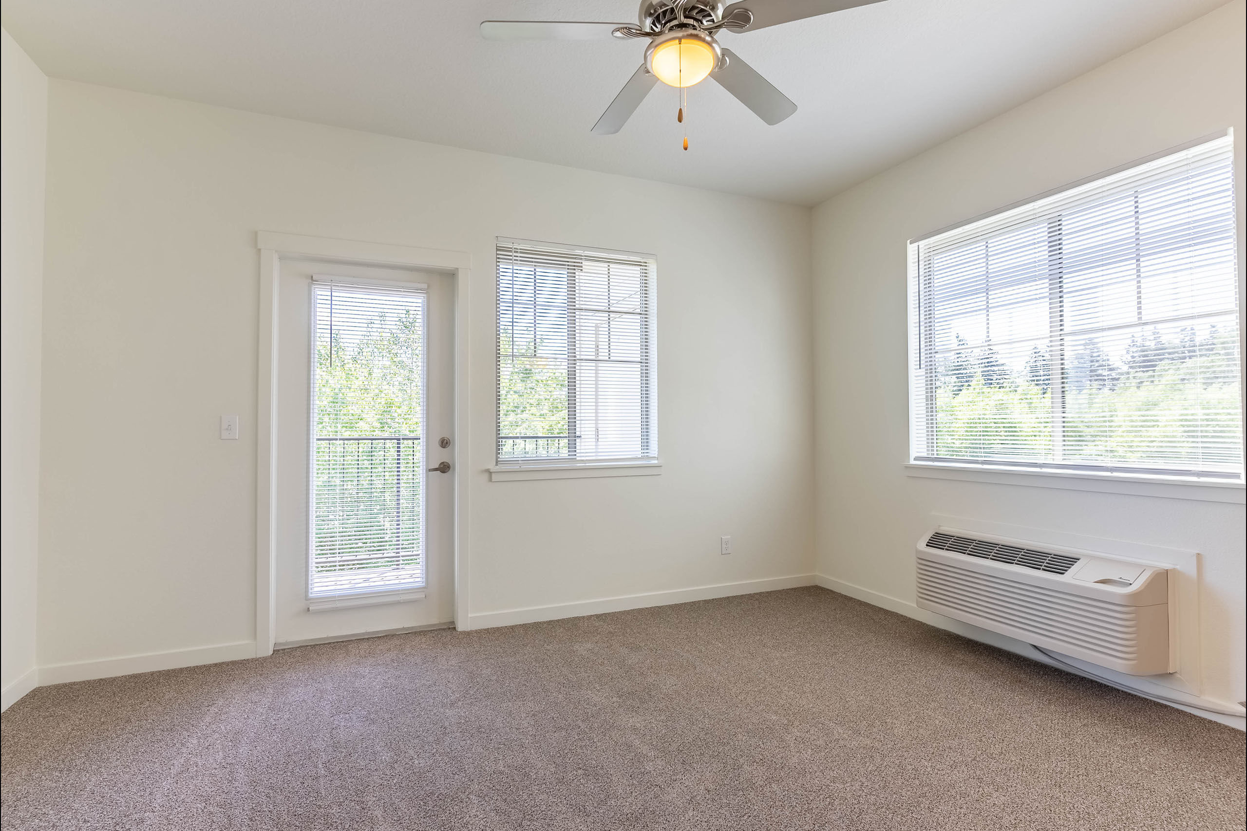 A room with a ceiling fan and a window with blinds.