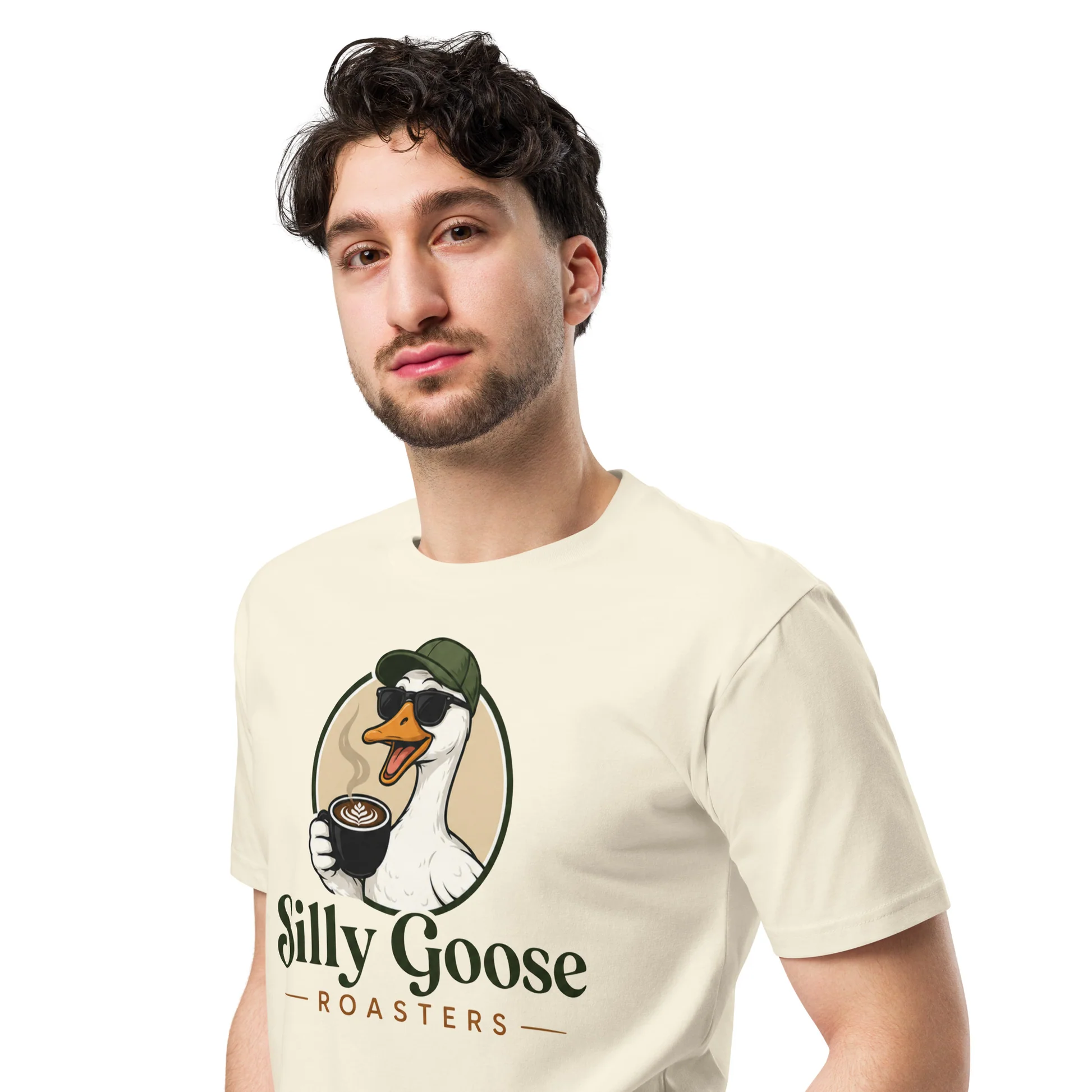A man wearing a cream-colored t-shirt with a logo of a goose holding a coffee cup. The goose is wearing sunglasses and a green baseball cap. The text "Silly Goose - ROASTERS -" is below the graphic.