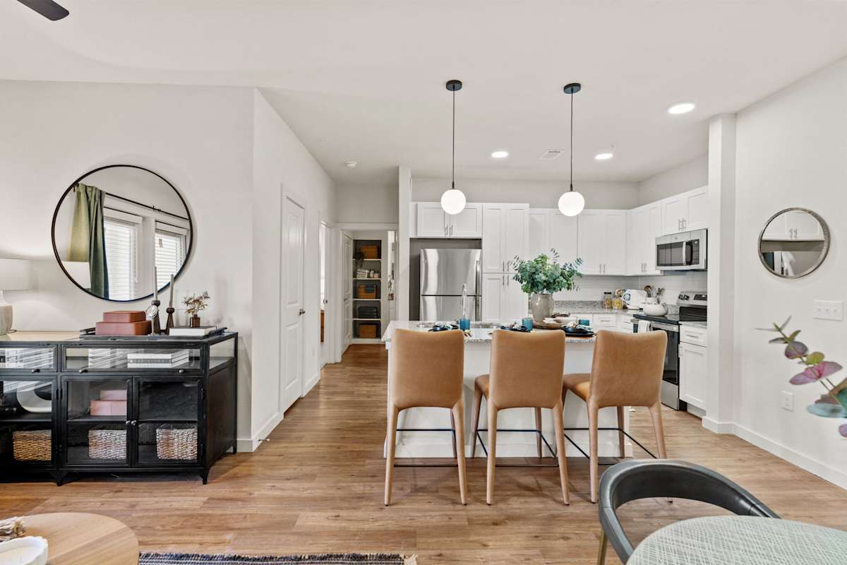 A modern kitchen with wooden floors and a central island. 