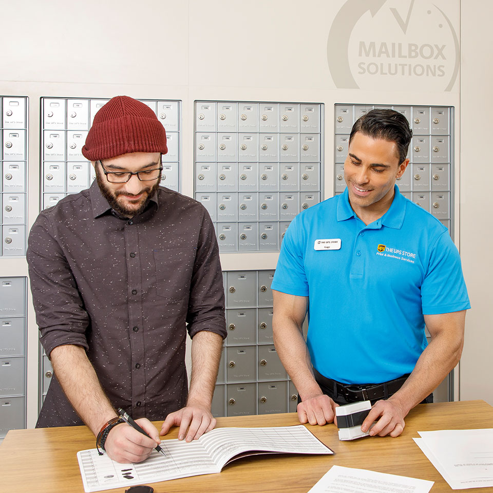 A UPS Store associate assisting customer with notarizing a document