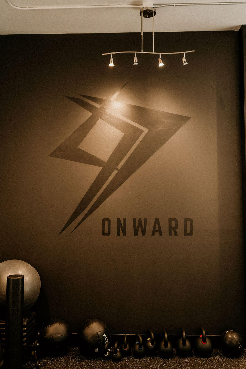The lobby of the Onward Physical Therapy clinic, featuring a wall with a black logo.