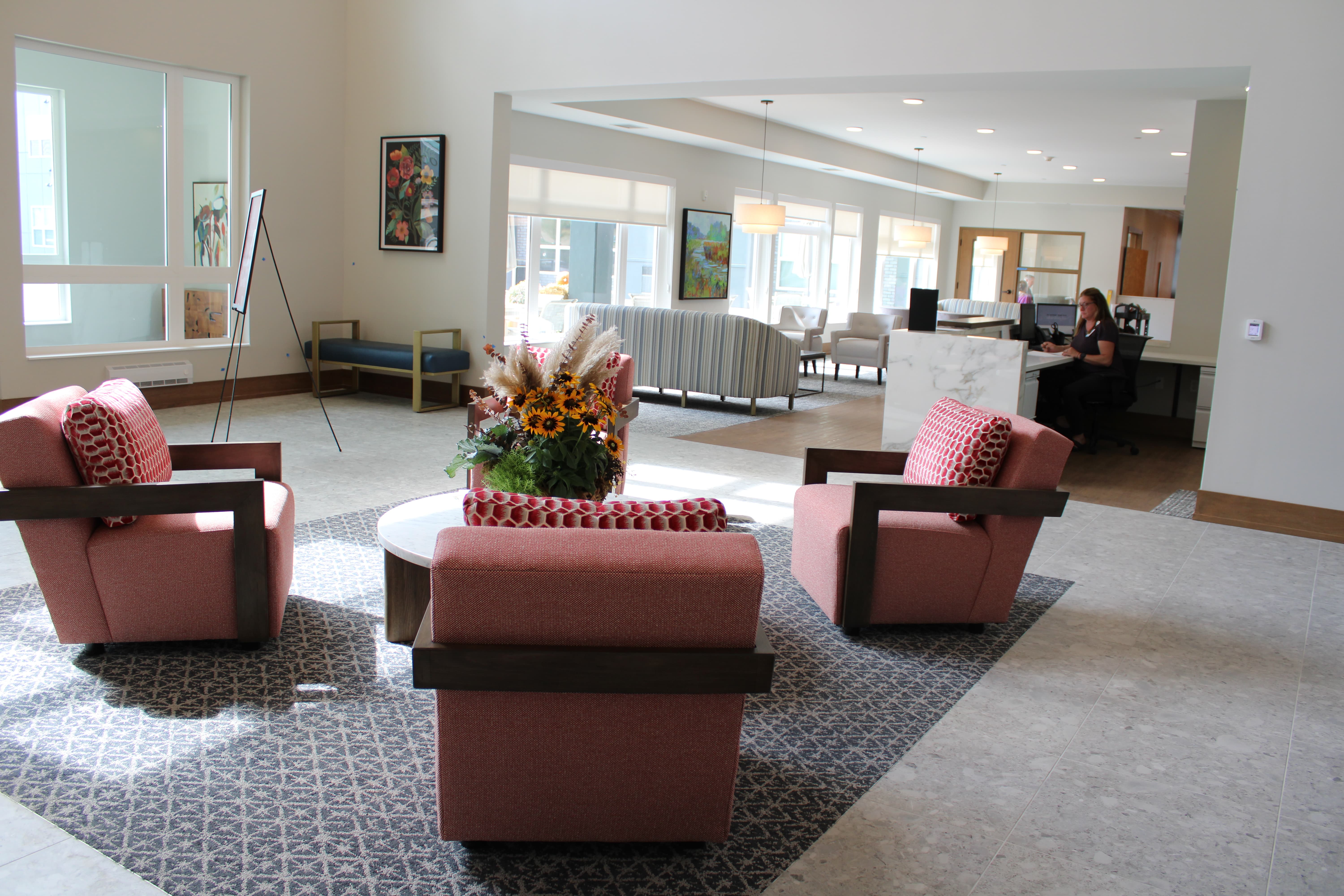This welcoming reception area at Saint Therese of Corcoran features comfortable seating, a coffee table, and a large window that provides natural light.