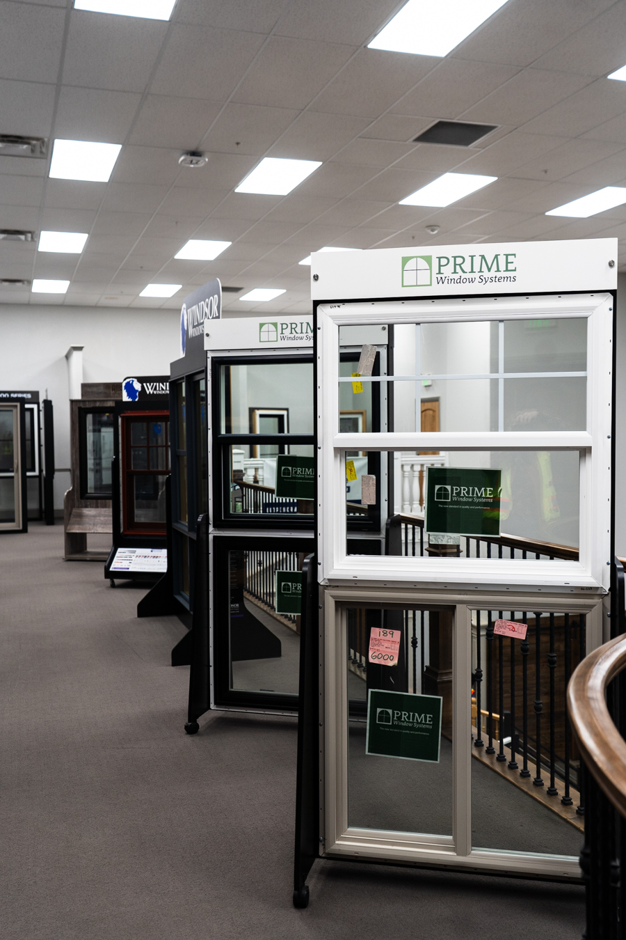 Builders FirstSource showroom displays Prime Window Systems, showcasing various window models in a well-lit interior space.