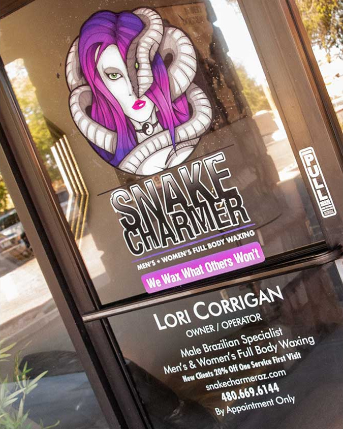 The front door of Snake Charmer Men's Body Waxing with logo decal.