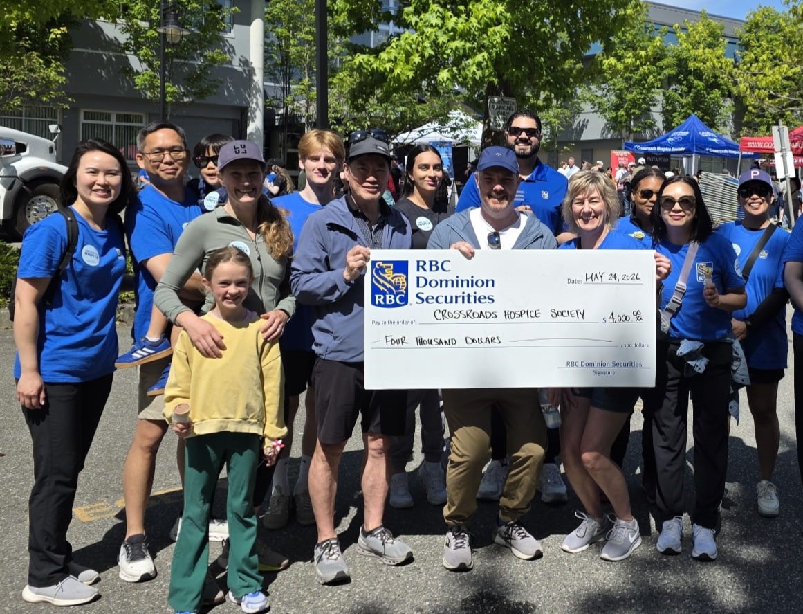 Edgington Wealth team presenting $4,000 donation check to Crossroads Hospice Society at outdoor charity event.