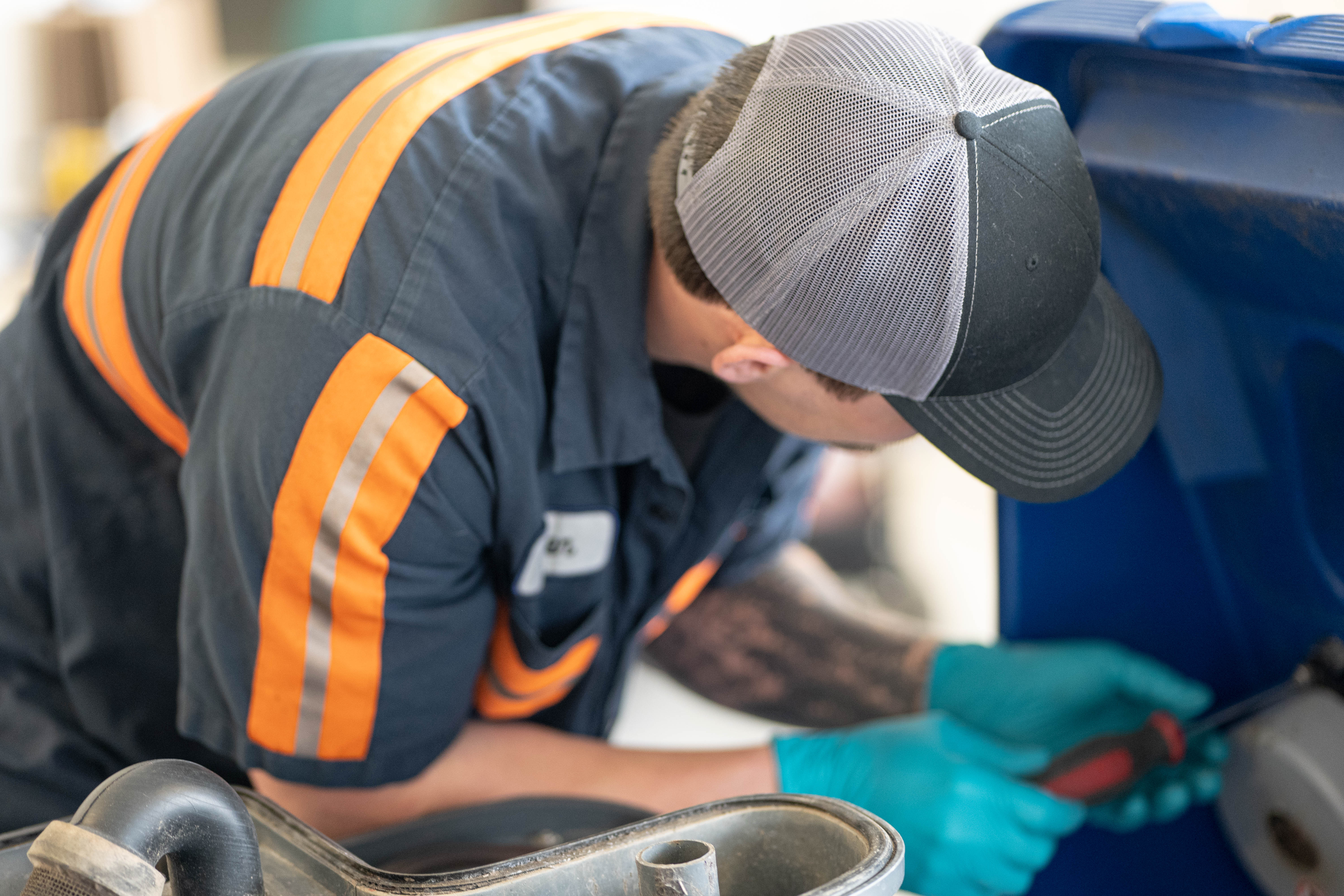A certified WaySolutions technician uses precision hand tools to repair internal components on a blue Kärcher Chariot stand-on floor scrubber in Layton, Utah. Our fully equipped mechanics ensure accurate diagnostics and permanent solutions for commercial cleaning equipment without causing damage to surrounding housings.