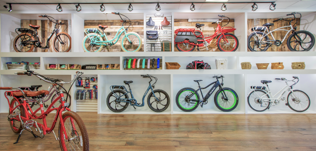 A display of Pedego ebikes in a Pedego shop. A red Pedego tandem is standing in the front.