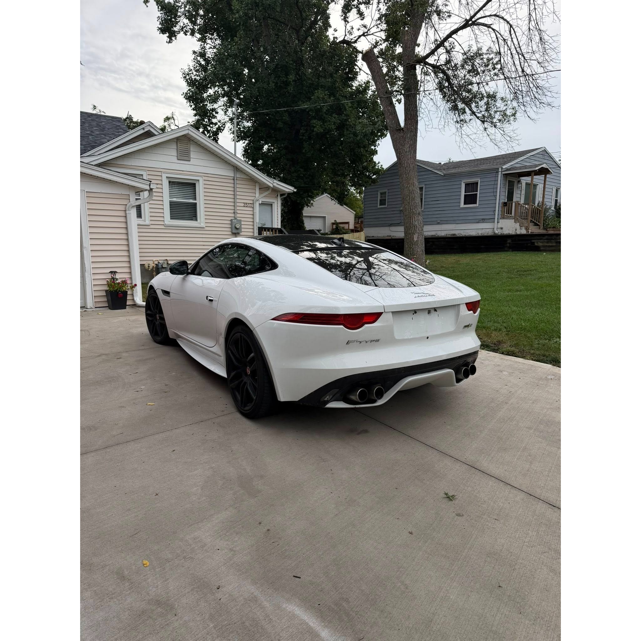 White luxury coupe parked in a driveway after detailing, showcasing a clean rear finish, glossy paint, and professional exterior detailing work.