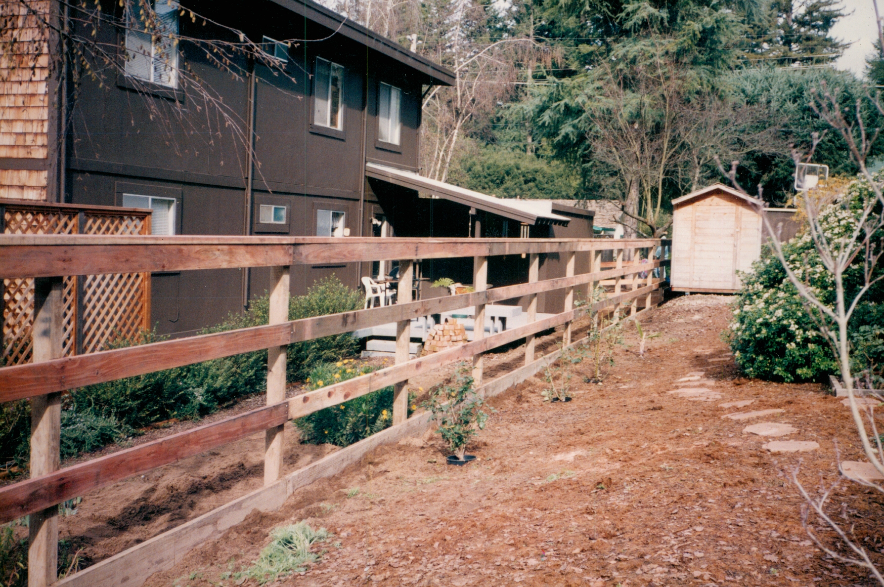 Split rail wood fence surrounding a landscaped property, adding a rustic and decorative outdoor boundary.