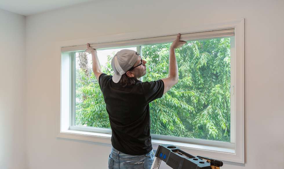 Budget Blinds of Greater Baltimore owner, Caleb, installing blinds at a Baltimore home